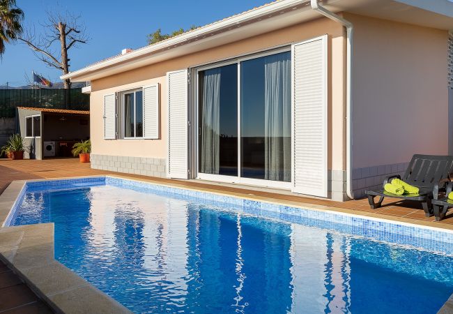 Piscine privée avec chaises longues et vue sur Funchal